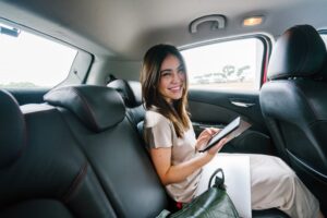 Young woman sits and reads in the backseat